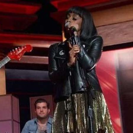 Marissa singing wearing a black leather jacket